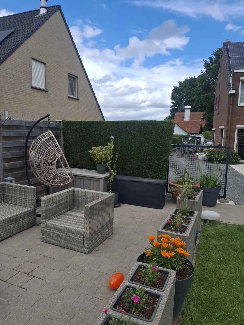 Terras met plantenbakken voor een gesnoeide haag