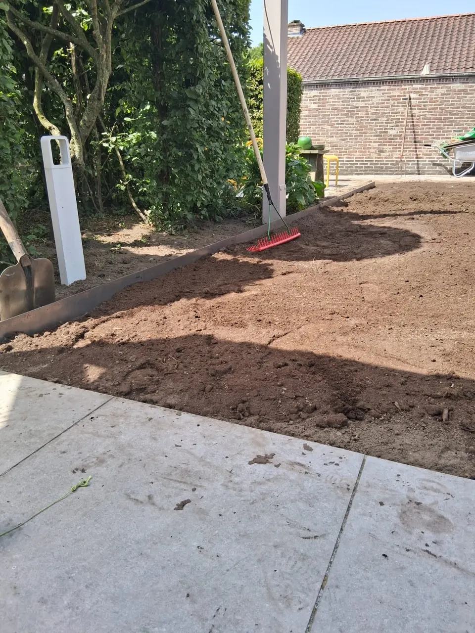 Rechte stalen afboording langs een border, met geëgaliseerde grond voor een nieuw gazon