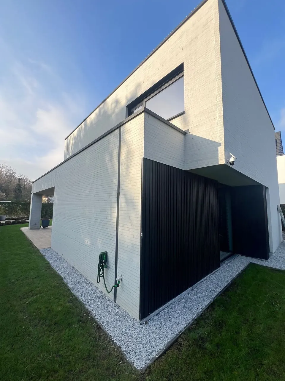 Wit grind rondom een moderne woning, strak afgeboord tegen het gazon