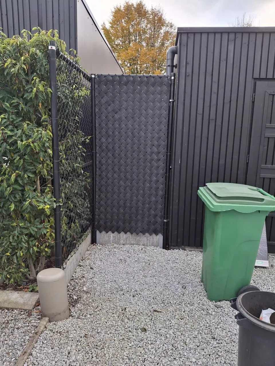 Lamellen in een draadafsluiting rond een containerplaats met grind