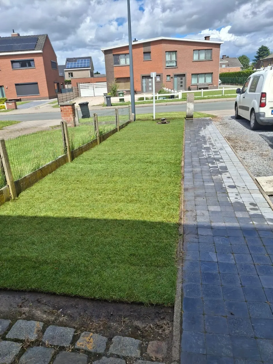 Pas gelegde graszoden in een voortuin langs een pad